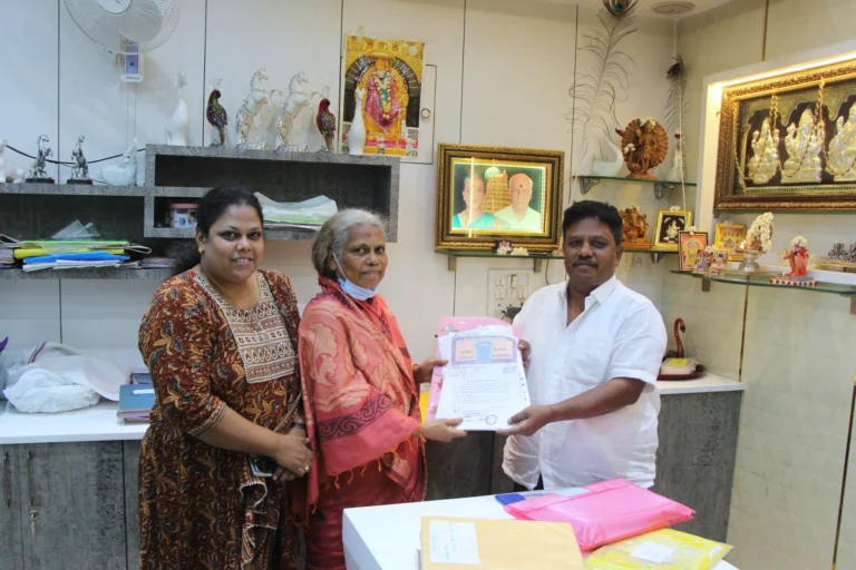 Property registration document handover between Anayaa Greenland team and happy plot buyers in office