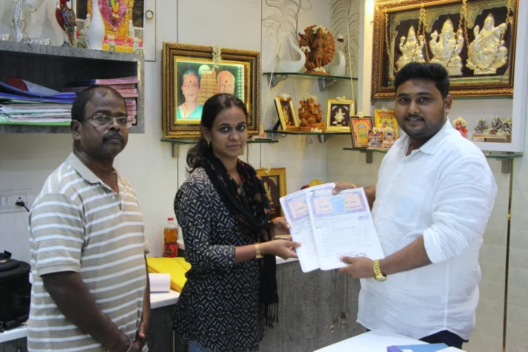 Property registration document handover between Anayaa Greenland team and happy plot buyers in office
