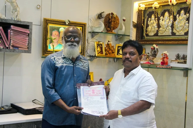 Property registration document handover between Anayaa Greenland team and happy plot buyers in office