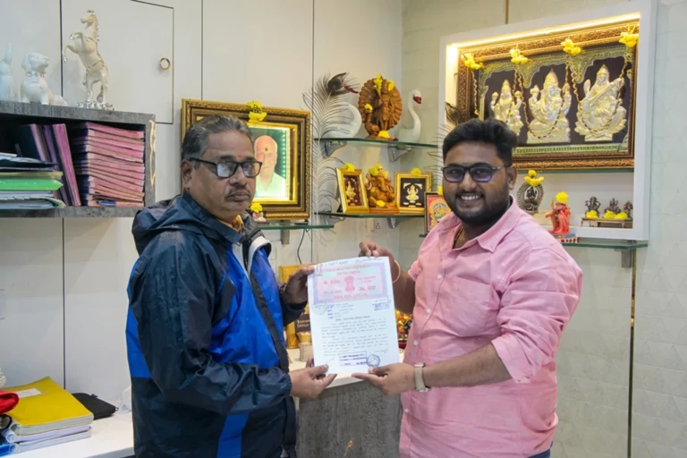 Property registration document handover between Anayaa Greenland team and happy plot buyers in office