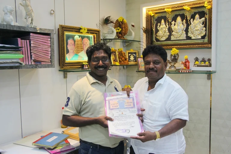 Property registration document handover between Anayaa Greenland team and happy plot buyers in office